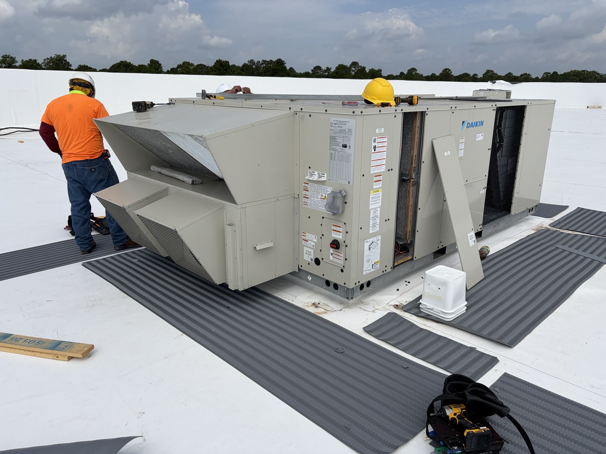 GreenTech commercial HVAC technicians installing Daikin rooftop units on Amazon warehouse new construction